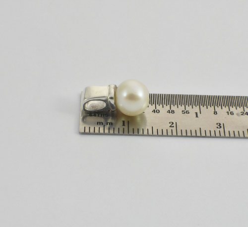 Dije de plata ley 0,950 con peso 2 gramos y perla natural de cultivo de 7 mm de diámetro.