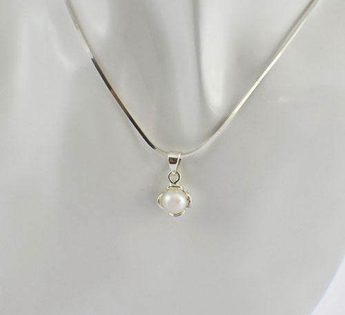 Dije de plata ley 0,950 con peso 2 gramos y perla natural de cultivo de 7 mm de diámetro. Diseño de 3 4 aros como pétalos.