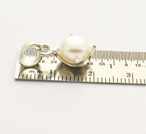 Dije de plata ley 0,950 con peso 2 gramos y perla natural de cultivo de 7 mm de diámetro. Diseño de 4 uñas.