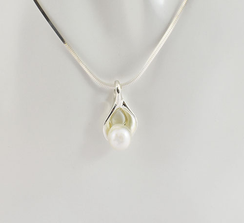 Dije de plata ley 0,950 con peso 2 gramos y perla natural de cultivo de 7 mm de diámetro. Diseño de ostra natural.
