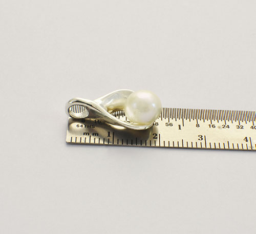 Dije de plata ley 0,950 con peso 2 gramos y perla natural de cultivo de 7 mm de diámetro. Diseño de ostra natural.