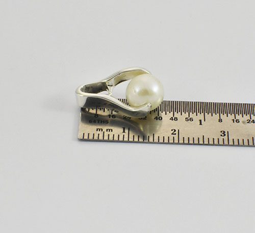 Dije de plata ley 0,950 con peso 2 gramos y perla natural de cultivo de 7 mm de diámetro. Diseño de pinza.