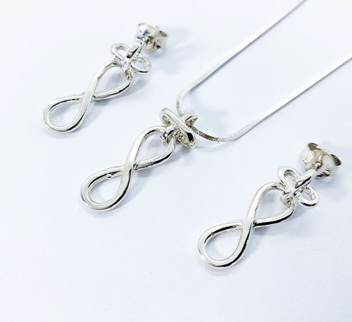 Set dije collar y aretes de plata ley 0,925, peso 7 gramos. Diseño sino infinito pequeñas.